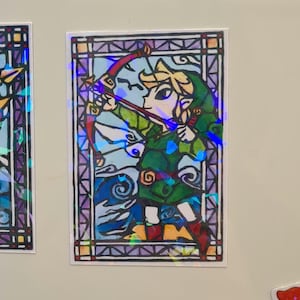 May include: A stained glass style illustration of a cartoon character holding a bow and arrow. The character is wearing a green tunic and has blonde hair. The background is a blue sky with white clouds.
