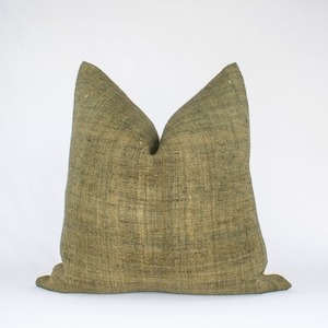 May include: A green, textured throw pillow with a square shape. The pillow is made of a woven fabric and has a subtle sheen.