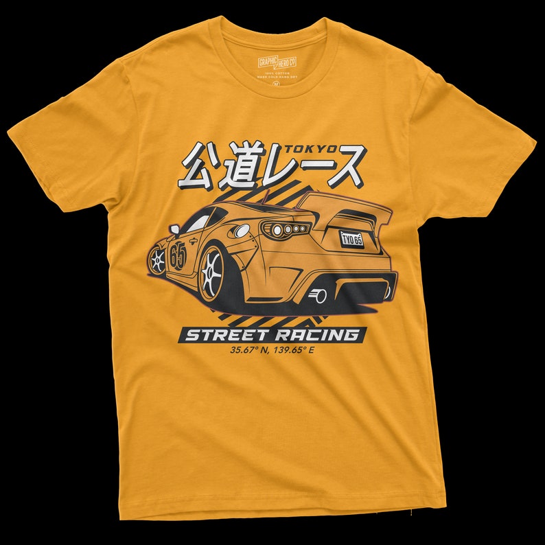 May include: A yellow t-shirt with a black and white graphic of a car with the text "公道レース" (Kōdō Rēsu) which means "Street Racing" in Japanese. The text "TOKYO" is above the car and the text "STREET RACING 35.67&deg; N, 139.65&deg; E" is below the car.