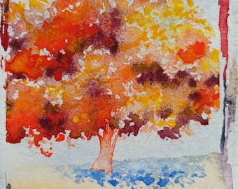 May include: Watercolor painting of a tree with orange, yellow, and red leaves. The tree is standing on a light brown background with blue accents.