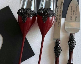 May include: Wedding champagne flutes and cake serving set. The flutes are burgundy with black lace accents and engraved names and dates. The cake knife and server have matching burgundy handles and black embellishments. The text reads "Benjamin and Marisa Laxson February 15, 2025".