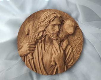 May include: A round, wooden relief carving depicting a figure with long hair and a beard, holding a lamb. The carving is in shades of brown and has a textured surface, suggesting a rustic or handcrafted style.