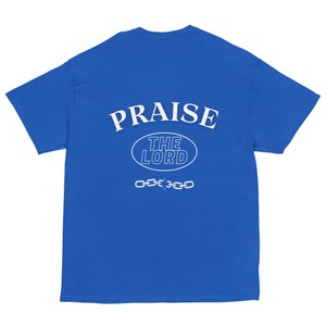 May include: A royal blue t-shirt with white text that reads "PRAISE THE LORD" in a circular design with a chain underneath.