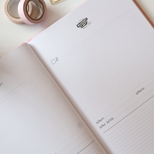 May include: A pink notebook with a black and white logo that says "The Bucket List Book". The notebook has a checklist with the words "When:", "Who with:", and "Where:" written on it.
