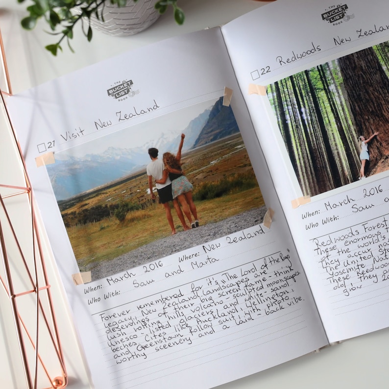 May include: A photo album page with a photo of a couple standing in front of a mountain range. The page is titled "Visit New Zealand" and includes the text "When: March 2016, Who With: Sam and Marta, Where: New Zealand". The text "Forever remembered for it's "The Lord of the Rings" landscapes are these enormous hills and valleys. The text continues with "Unesco listed volcanoes sculpted moonscapes, lush rolling hills, beaches, cities like Auckland and Wellington, worthy scenery and a laid back vibe."