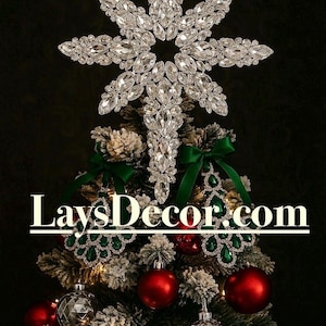 May include: A Christmas tree with red and silver ornaments, green bows, and a large, sparkling star tree topper. The tree is decorated with lights and has the text "LaysDecor.com" across the image.