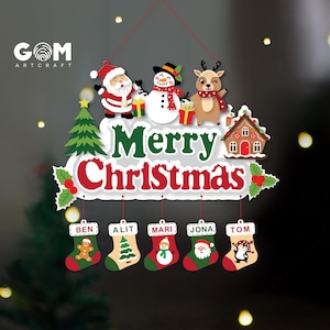 May include: A decorative Christmas wall hanging featuring a white sign with the text Merry Christmas in green and red. It includes illustrations of Santa, a snowman, a reindeer, a tree, and a house, with five hanging stockings labeled Ben, Alit, Mari, Jona, and Tom.