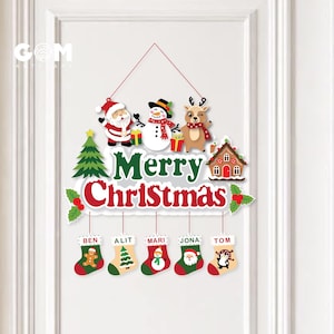 May include: A hanging Christmas wall sign featuring a green tree, Santa Claus, a snowman, a reindeer, and a gingerbread house. The text reads Merry Christmas. Below, five hanging stockings are labeled Ben, Alit, Mari, Jona, and Tom.