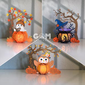 Puede incluir: Tres recortes de papel con temática de Halloween. Uno presenta un fantasma leyendo un libro, otro un caldero de bruja y el último un búho. Cada recorte incluye una calabaza y un árbol con hojas de otoño. El recorte del fantasma tiene la palabra "Spooky" en el libro.