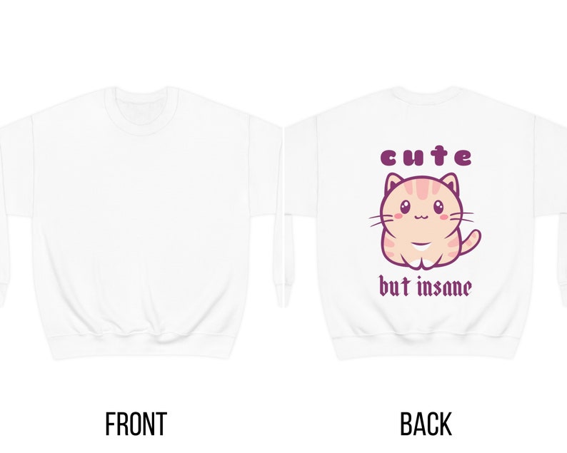 Może przedstawiać: Biała bluza z uroczym kresk&oacute;wkowym kotem i napisem "cute but insane" na plecach.
