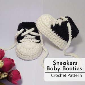 Könnte beinhalten: Weiße und schwarze gehäkelte Babyschuhe in Form von Sneakern mit weißen Schnürsenkeln. Sneakers Baby Booties Crochet Pattern.