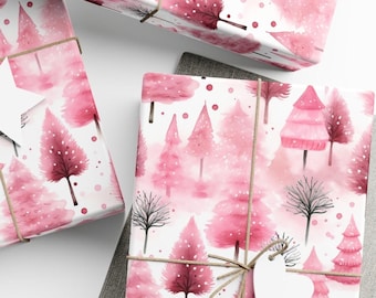 May include: Pink watercolor Christmas wrapping paper with a pattern of trees and snowflakes. The paper is tied with twine and a white heart-shaped tag.