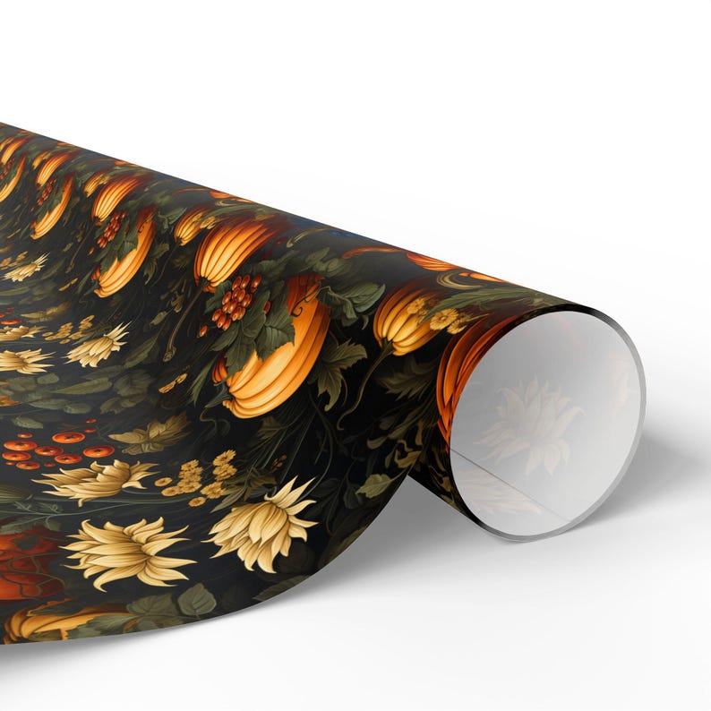 Op de afbeelding: Een rol donkerblauw cadeaupapier met een herhalend patroon van oranje pompoenen, groene bladeren en gele bloemen.