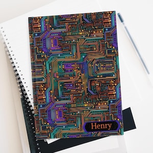May include: A black notebook with a colorful circuit board design and the name "Henry" printed in orange on the front.