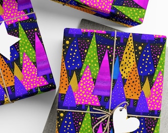 Op de afbeelding: Cadeaus verpakt met kleurrijke abstracte kerstboompatronen. Het cadeaupapier toont bomen in roze, groen, blauw en goud tegen een donkerblauwe achtergrond. Elk pakket is vastgebonden met touw en een wit hartvormig label.