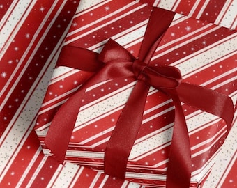 May include: A wrapped gift with red and white striped paper and a burgundy ribbon tied in a bow. The paper has a pattern of diagonal stripes and small white stars. The bow is centered on the gift.