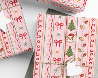 Puede incluir: Papel de regalo rosa con temática navideña con lazos rojos, árboles de Navidad verdes, caras de Papá Noel y luces de cadena. Los regalos están atados con hilo y una etiqueta blanca en forma de corazón.