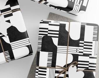 May include: Black and white wrapping paper with a geometric pattern of piano keys and abstract shapes. The paper is tied with twine and a white heart-shaped tag.