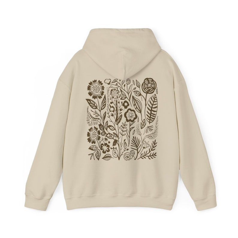 K&ouml;nnte beinhalten: Ein beiger Hoodie mit einem braunen Blumendruck auf der R&uuml;ckseite. Der Druck zeigt eine Vielzahl von Blumen, Bl&auml;ttern und Stielen.