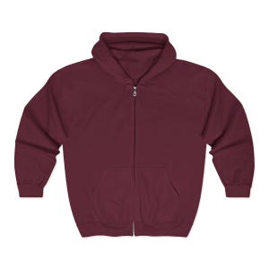May include: A maroon zip-up hoodie with a hood and a kangaroo pocket. The hoodie has a full-length zipper and is made of a soft, comfortable material. The sleeves are long and the cuffs are ribbed.