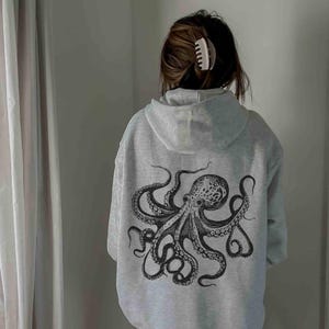 May include: A gray hoodie with a black octopus graphic printed on the back.