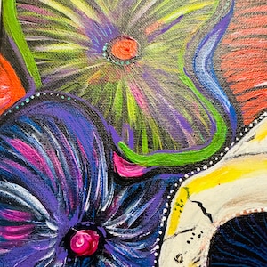 Puede incluir: Un primer plano de una pintura que representa una calavera adornada con flores de colores. Las flores est&aacute;n pintadas en tonos de morado, azul, verde y rosa. La calavera est&aacute; pintada de blanco con detalles negros. El fondo es de un rojo vibrante.
