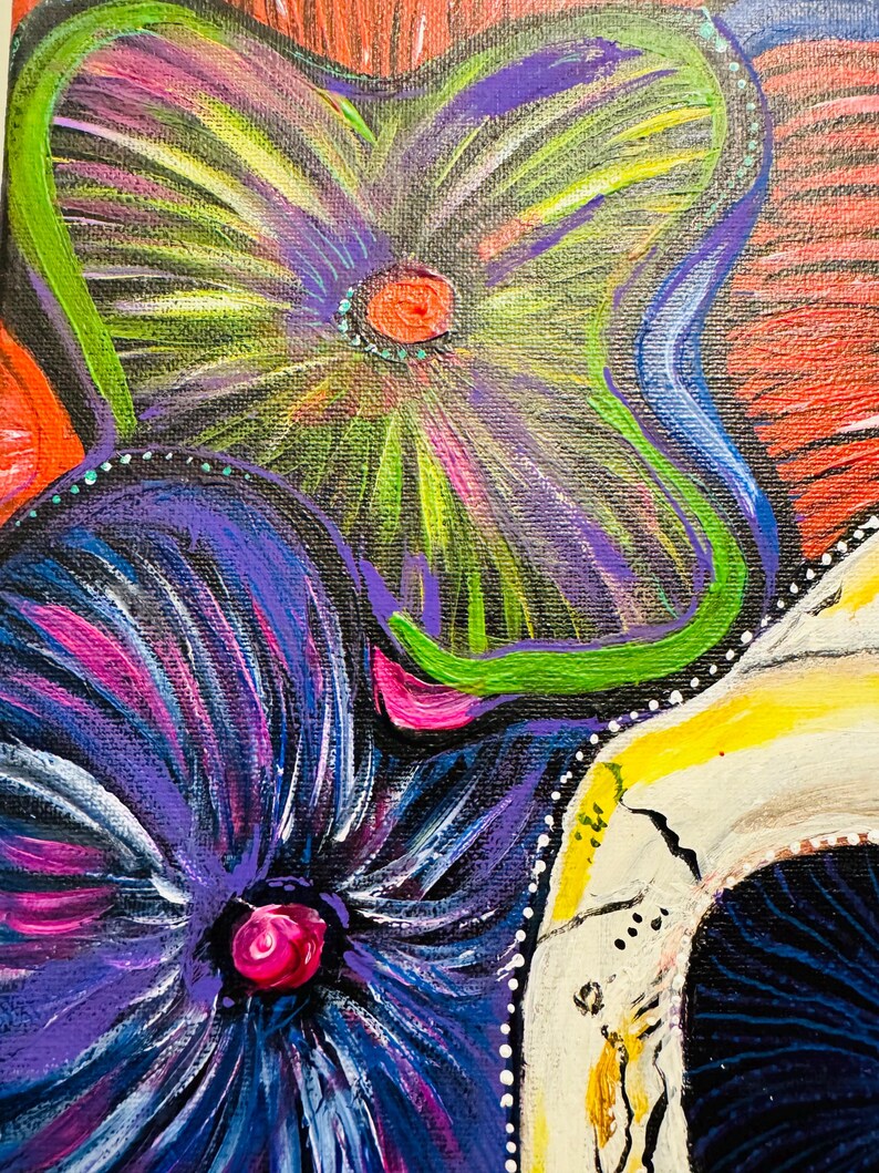 Puede incluir: Un primer plano de una pintura que representa una calavera adornada con flores de colores. Las flores est&aacute;n pintadas en tonos de morado, azul, verde y rosa. La calavera est&aacute; pintada de blanco con detalles negros. El fondo es de un rojo vibrante.