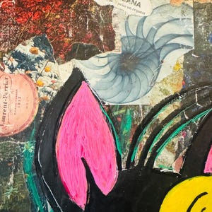 May include: A black and yellow cartoon character with pink ears. The character is painted on a canvas with a collage of paper scraps and text. The text includes "DOLCE & GABBANA" and "MAISON FONDEE 1812".