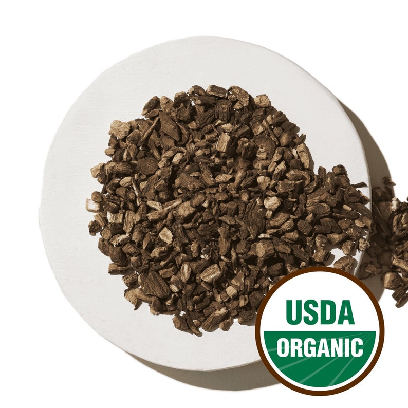 Może przedstawiać: Biały ceramiczny talerz z kupką suszonej, brązowej, organicznej korzenia łopianu. Talerz ma po prawej stronie pieczęć USDA Organic.
