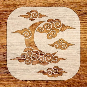 May include: Wooden coaster with a crescent moon and cloud design. The moon and clouds are a darker wood color, set against a lighter wood background. The clouds have a swirling pattern.