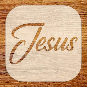 May include: A light-colored wooden square with rounded corners. The word "Jesus" is laser-cut in a flowing, cursive font, with a darker wood tone. The background has a wood grain pattern.