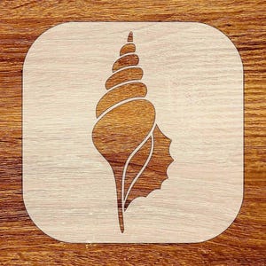 May include: A wooden stencil featuring a detailed seashell design. The seashell is a warm brown color, with a spiral top and a textured body. The stencil is set against a light wood grain background, creating a contrast in tones.