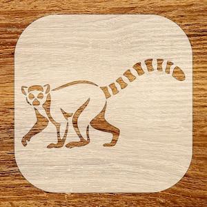 Puede incluir: Un posavasos de madera con un diseño de lémur. El lémur está representado en un estilo minimalista, con un contorno marrón claro sobre un fondo beige claro. La cola del lémur es rayada y el posavasos tiene esquinas redondeadas.