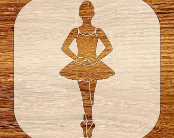 May include: A wooden cutout of a ballerina in a tutu, arms crossed in front. The ballerina is light brown, set against a light wood grain background. The cutout is in a rounded square shape.