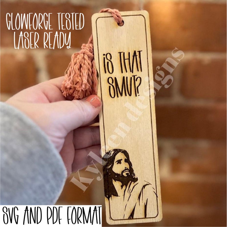 May include: A wooden bookmark with a tassel, featuring a laser-engraved image of Jesus and the text "Is That Smut?" The bookmark is labeled "Glowforge Tested Laser Ready" and "SVG and PDF Format".