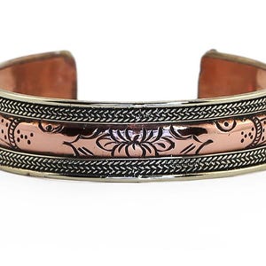 May include: A copper and silver bracelet with an intricate floral design. The bracelet is open and adjustable.