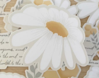 May include: A set of white daisy and honeycomb stickers with a bee and leaf accents. The stickers are on a light brown wooden surface.