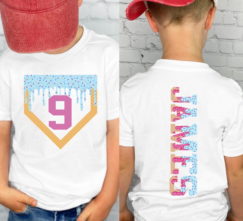 May include: White t-shirt with a baseball home plate design featuring a number 9 and blue icing drips. The back of the shirt displays the name "JAMES" vertically in a donut-themed font. The shirt is worn by a person wearing a red baseball cap.