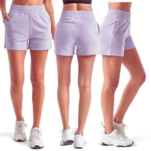 May include: Light purple athletic shorts with an elastic waistband and pockets. The shorts are made of a soft material and are shown from multiple angles. The shorts are paired with white athletic shoes.