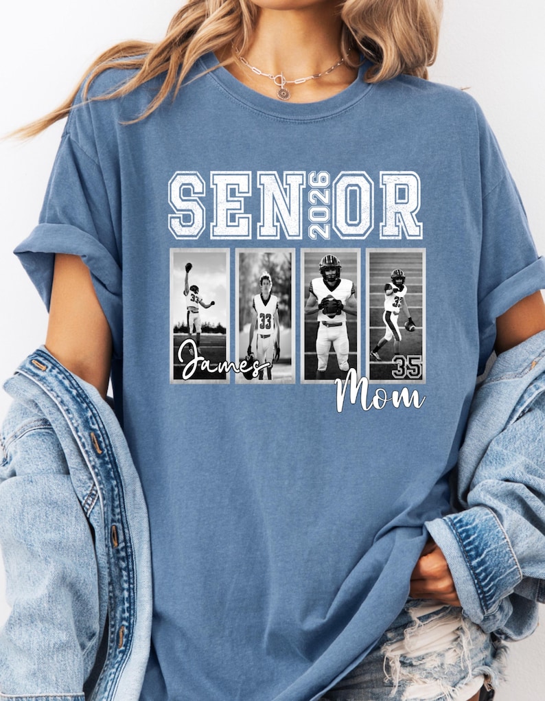 May include: A blue t-shirt with the words "SENIOR 2026" in white block letters. Below the text are four black and white photos of football players. The names "James" and "Mom" are written in cursive.