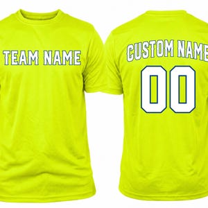 May include: A neon yellow short-sleeve t-shirt shown from the front and back. The front features the text TEAM NAME in white with a dark blue outline. The back displays the text CUSTOM NAME above the large white number 00 with a dark blue outline.