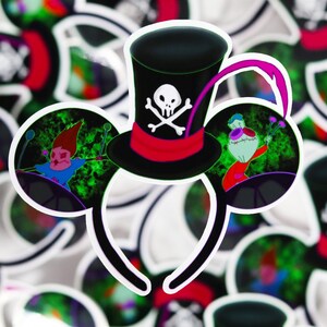 May include: A pair of black Mickey Mouse ears with a green, black, and red skull and crossbones hat on top. The ears have a green, black, and red image of a character playing drums on the left ear and a green, black, and red image of a character playing a musical instrument on the right ear.