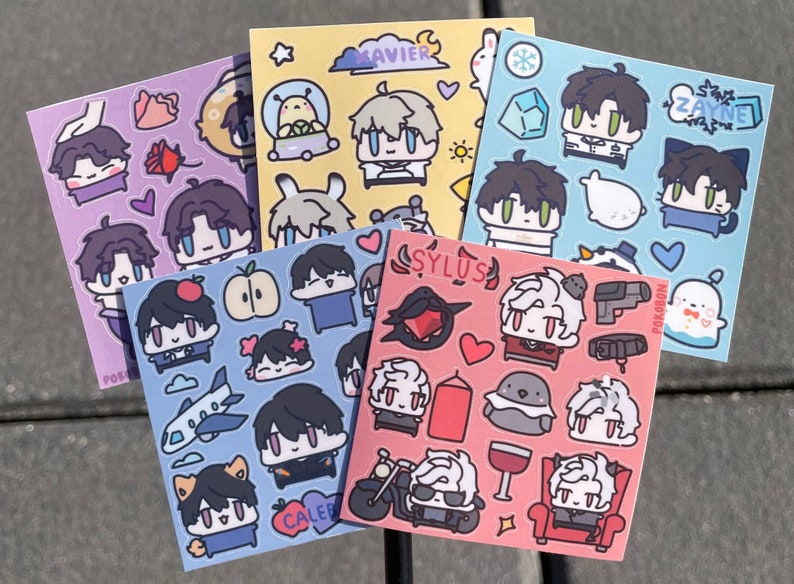 Op de afbeelding: Set van 6 sticker vellen met verschillende karakters en ontwerpen. Elk vel heeft een andere achtergrondkleur en toont een andere karakternaam. De karakters zijn getekend in een cartoon stijl en bevatten een verscheidenheid aan accessoires en objecten.