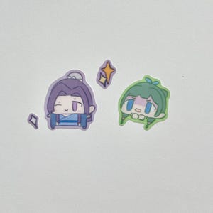 May include: A collection of stickers featuring anime-style characters. One sticker depicts a purple-haired character in blue clothing, while the other shows a green-haired character. Decorative star and diamond shapes are also included.