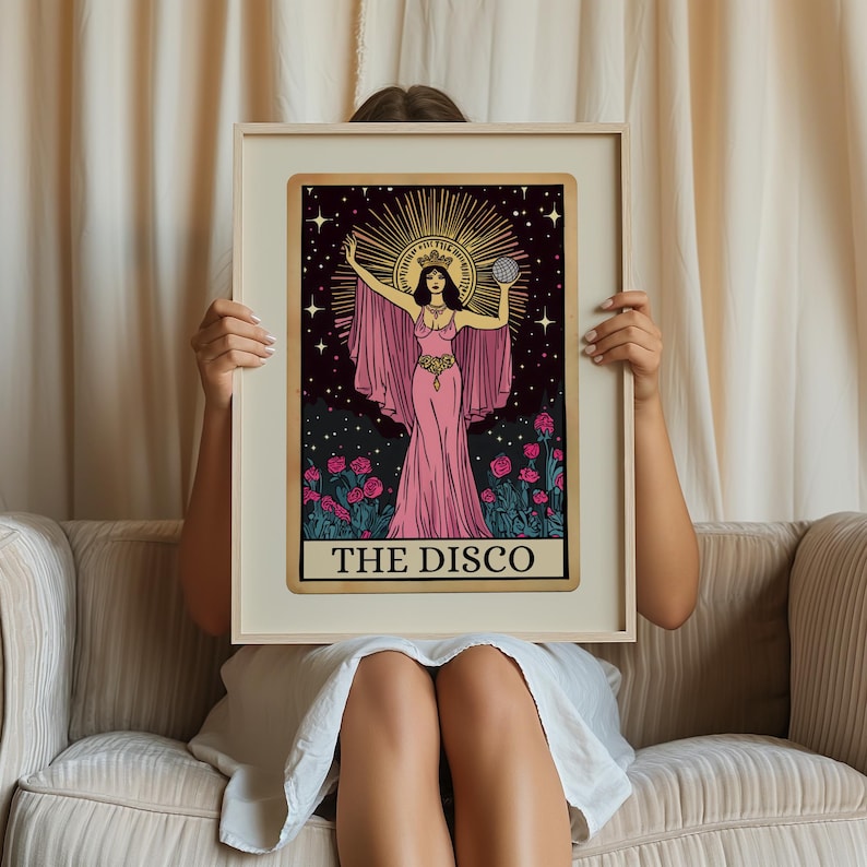 May include: A framed tarot card print featuring a woman in a pink gown holding a disco ball. The artwork has a gold border and the text "THE DISCO" at the bottom. The background is black with stars and a sunburst halo.