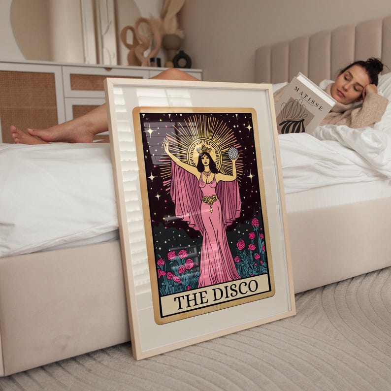 May include: Framed art print featuring a woman in a pink gown with a gold halo, holding a globe. The artwork is set against a dark background with stars and flowers, with the text "THE DISCO" at the bottom.