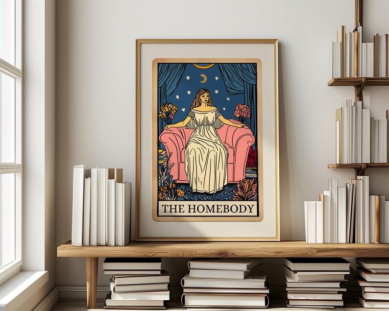 May include: A tarot card illustration with a woman sitting on a pink couch. The card is titled "The Homebody" and features a blue background with stars and a crescent moon.