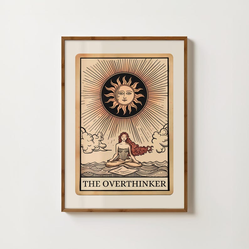 Peut inclure: Une carte de tarot de style vintage avec une femme m&eacute;ditant en position de lotus sur une &eacute;tendue d'eau. Le soleil brille au-dessus d'elle, et la carte indique "The Overthinker".