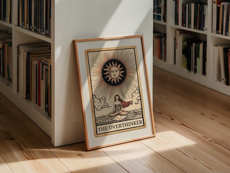 Peut inclure: Une impression encadr&eacute;e d'une carte de tarot avec une femme assise sur une vague avec un soleil au-dessus d'elle. La carte est intitul&eacute;e "The Overthinker".