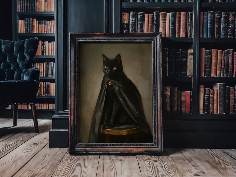 May include: A black cat wearing a black cape with a gold buckle sits on a wooden stool in a framed painting. The painting is set against a dark wood bookshelf with books.